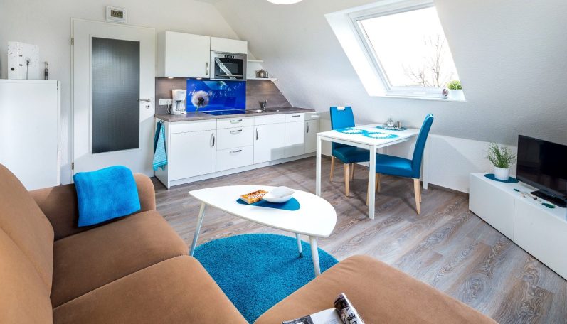 Helle, moderne Wohnung mit gemütlichem Wohnzimmer, Essbereich und blauen Akzenten.